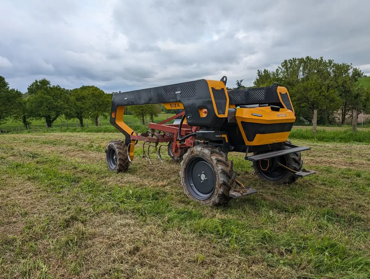TOOGO dans une prairie arborée, un outil attelé au centre